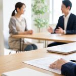 雇用契約書を確認する人事担当者と、話し合うパート従業員と正社員